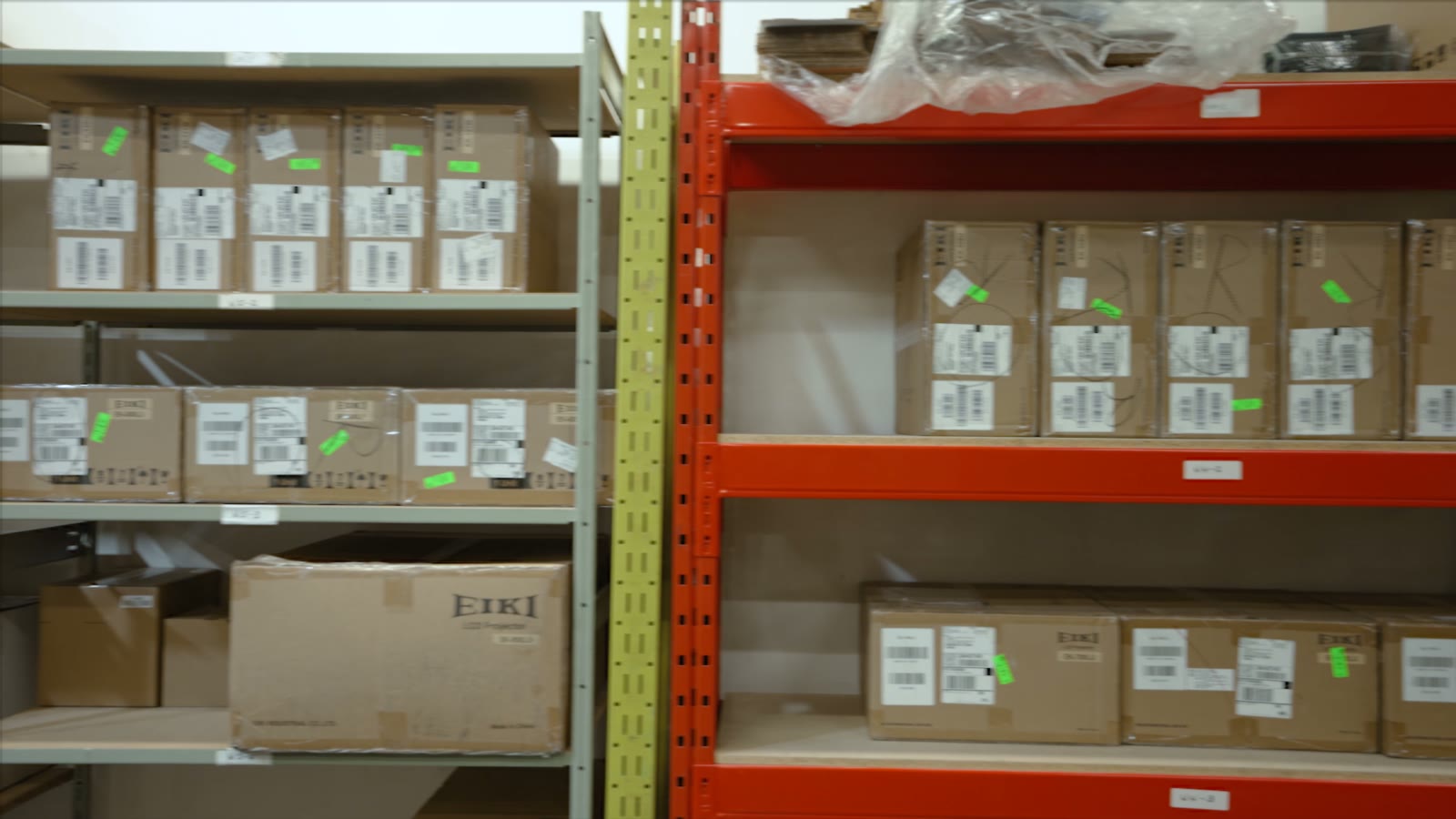 Warehouse racking stacked with boxed EIKI projector stock